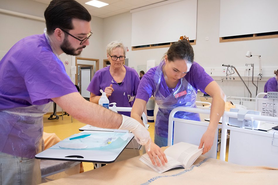 Sjuksköterskestudenter övar på omvårdnad på dockor tillsammans med lärare. Foto.