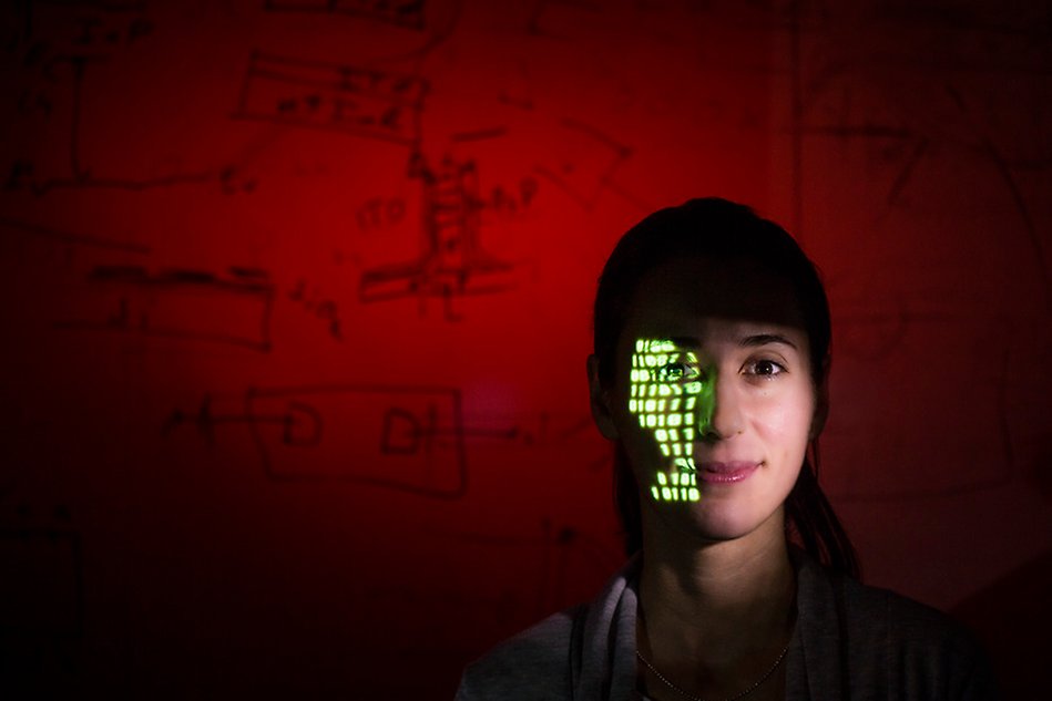 Picture of a woman with a projection of green light in the face. Photo.