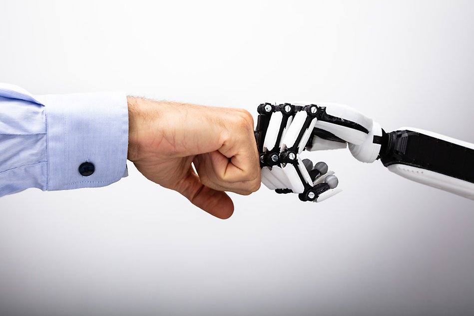A human hand and a robot hand bump into each other.