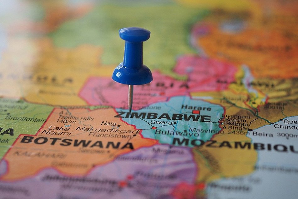 A large, blue pin in the middle of a map, displaying Zimbabwe and surrounding countries. Photo. 