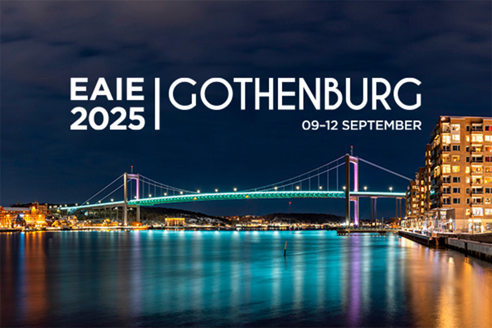 En bild tagen i mörker med en upplyst bro i fokus. Texten EAIE 2025 Gothenburg 09-12 september syns på.  