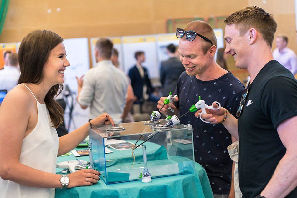 Två besökare provar en slags apparat i en monter på Utexpo.