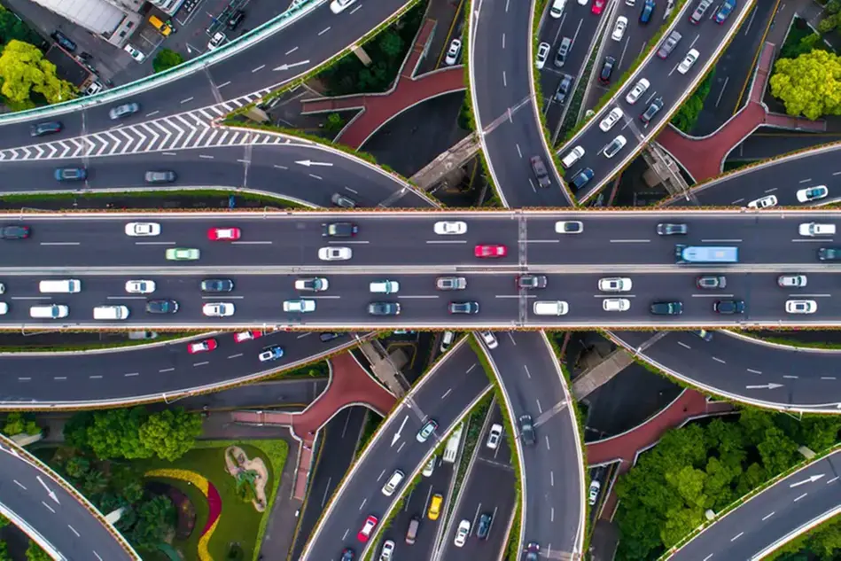 Aerial view of a highly complicated turnpike with motorway overpasses in several levels full of vehicles. Photo.