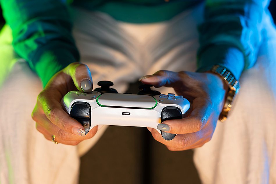 A person is holding a game console in his hands. Photo.