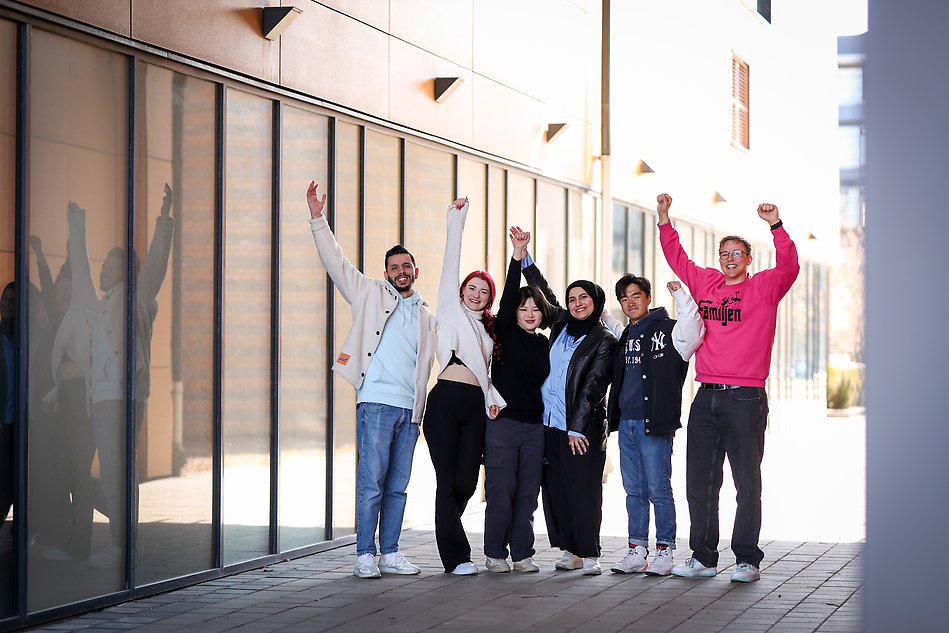 A group of happy students standing outside of campus. Photo. 