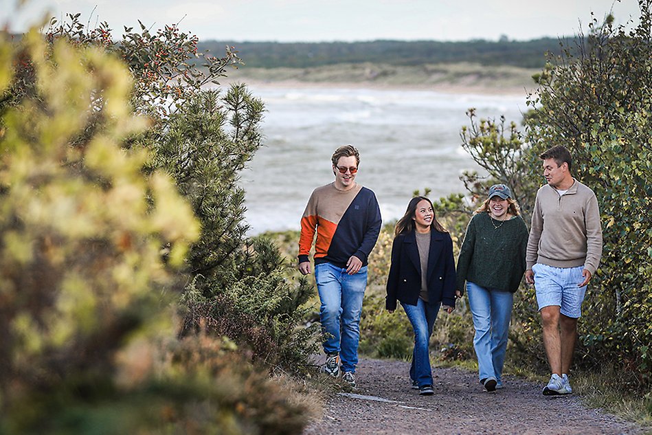 A group of students walking in the nature by the beach. Photo. 