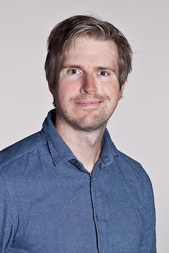 Portrait of a man with blonde hair, wearing a blue shirt. Photo.