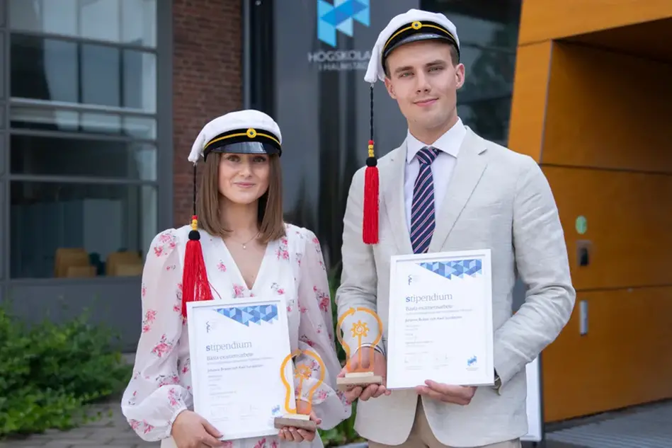 Tre personer tittar på två killar som visas på en stor skärm