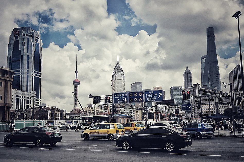 Trafik på en stadsgata. Vägskyltar med kinesiska tecken. Fotografi.
