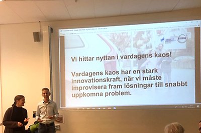 kvinna och man vid stor bildskärm
