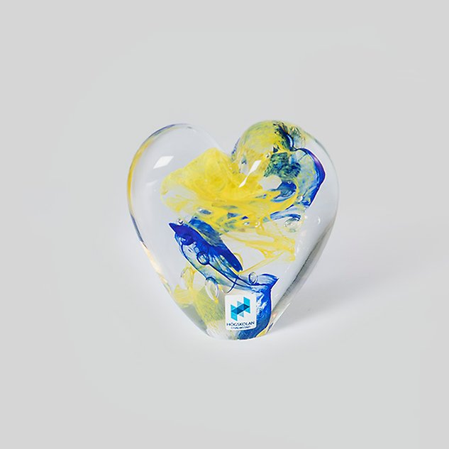 Glass art in yellow and blue shaped as a heart. Photo.