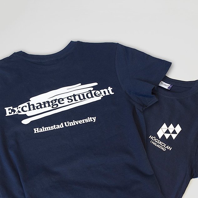A dark blue t-shirt with a print with the text ”Exchange student” on the chest lies against a white background. Photo.