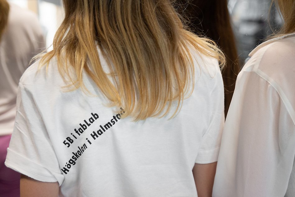 En femteklassare har på sig en t-shirt som är tryckt i Fab Lab. T-shirten är tryckt med texten "5B i Fab Lab Högskolan i Halmstad".