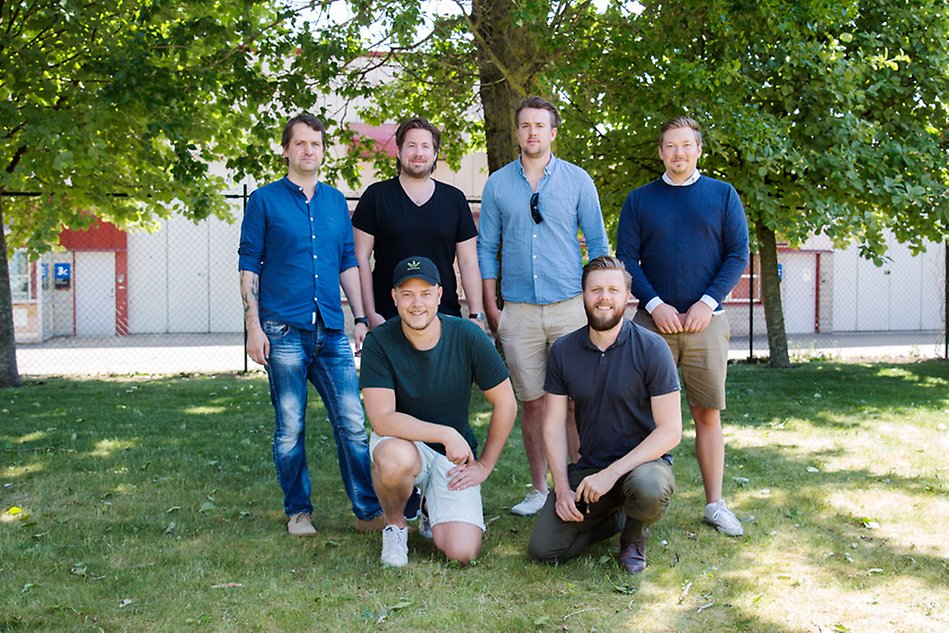 A photo of six young men standing in two rows.