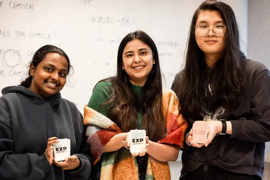 Three students posing with their design prototypes.