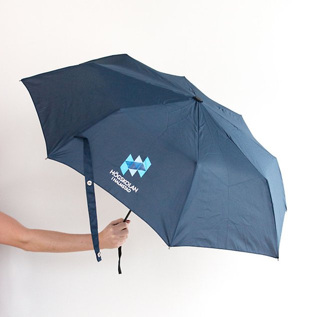 A hand holding up a dark blue, unfolded umbrella. Photo.