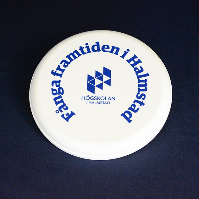 A white frisbee with the text ”Capture the future in Halmstad” in Swedish. Photo.