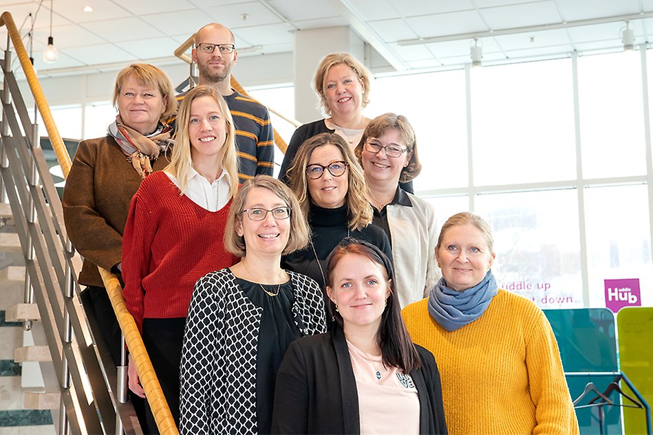 Gruppbild av nio forskare som står i en trappa. Foto.