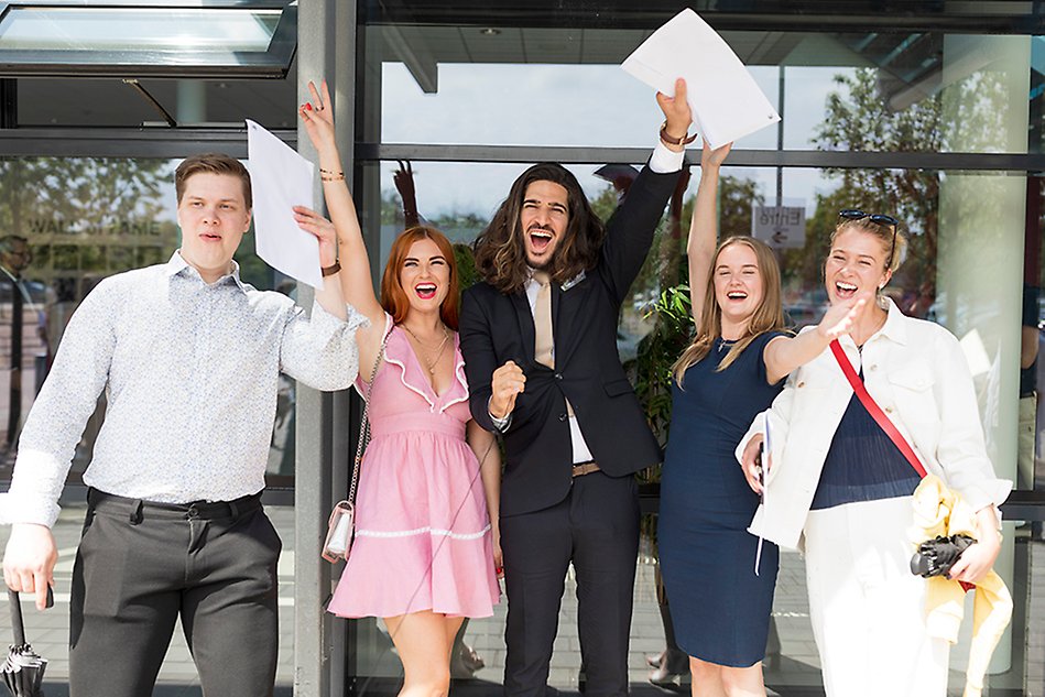 Happy students cheering. Photo.